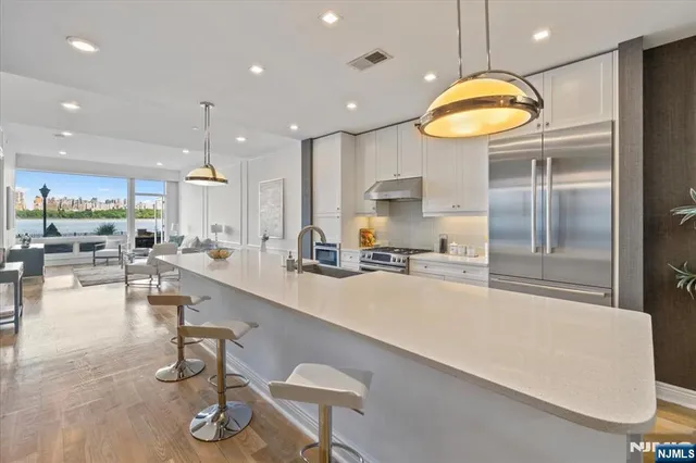 a large kitchen with a large counter top appliances and a living room view