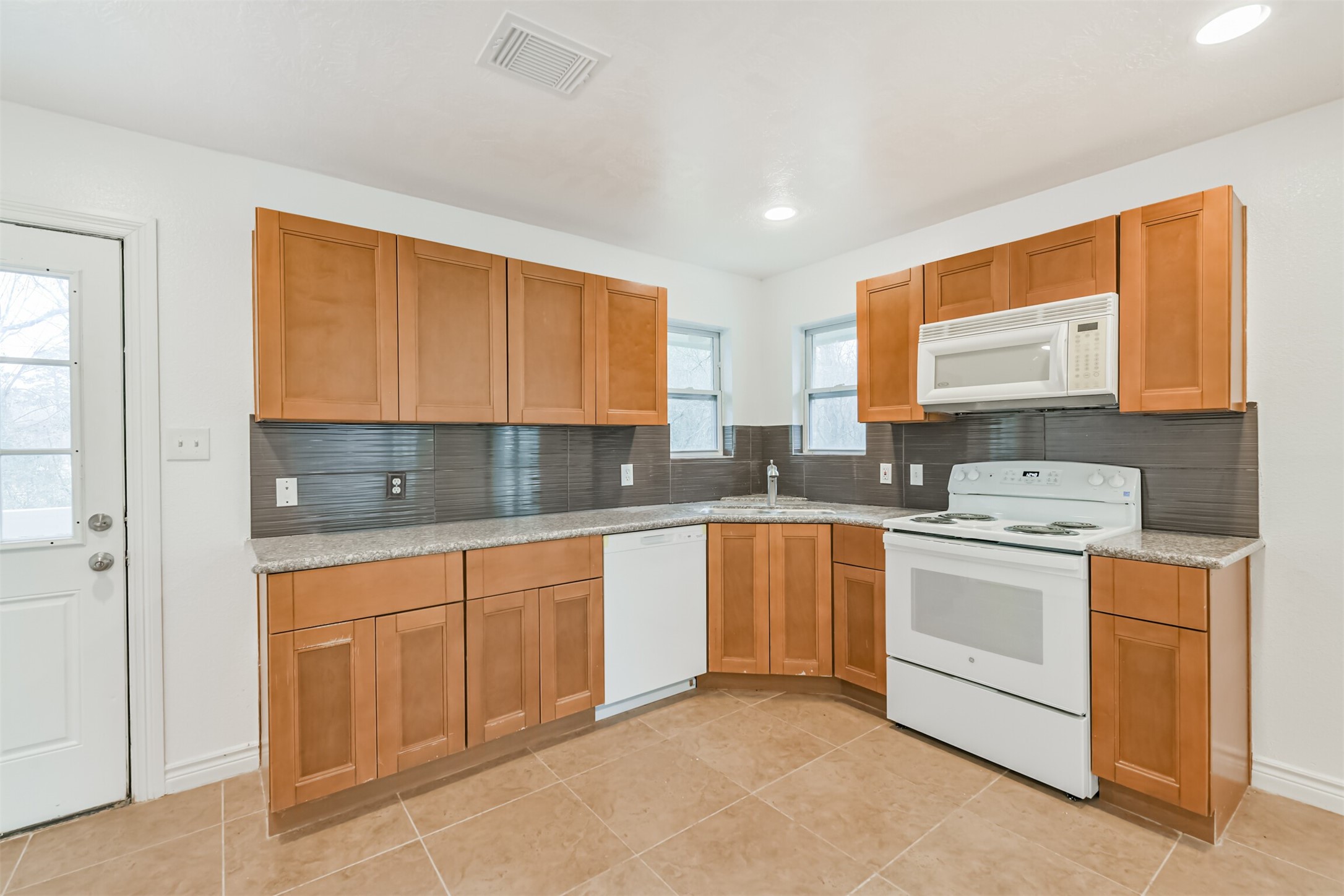 10412 Ehlers Road Conroe, TX 77302 - Photo 9 of 37 a kitchen with stainless steel appliances granite countertop a stove a sink and a microwave