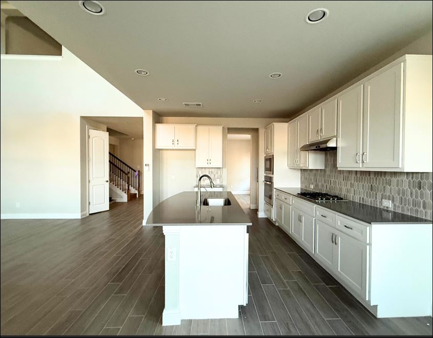 109 Rocky River Road Georgetown, TX 78628 - Photo 2 of 10 Prepare meals and entertain guests with ease in this spacious kitchen featuring a central island and contemporary tile flooring.