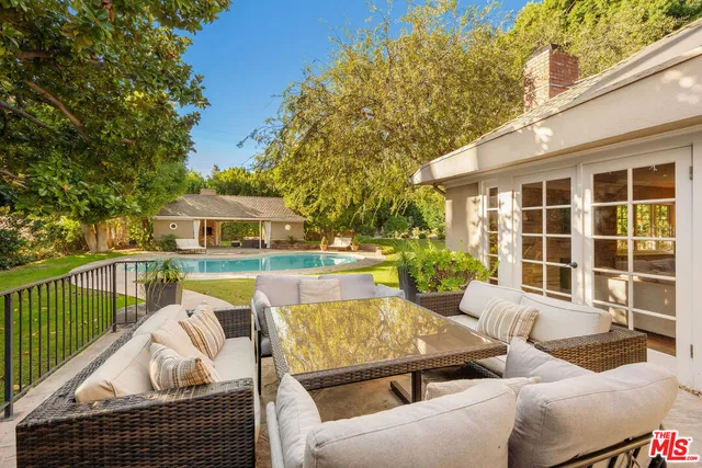a view of a patio with couches chairs and wooden floor