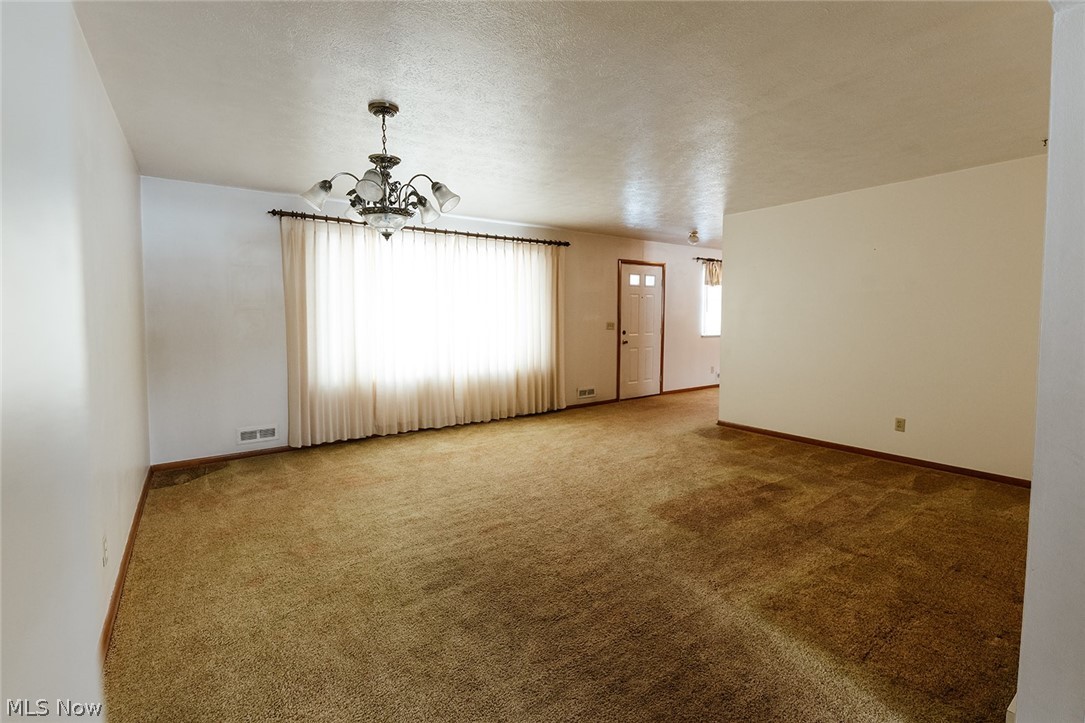 19545 Alexander Road Bedford, OH 44146 - Photo 4 of 29 Carpeted empty room with a chandelier
