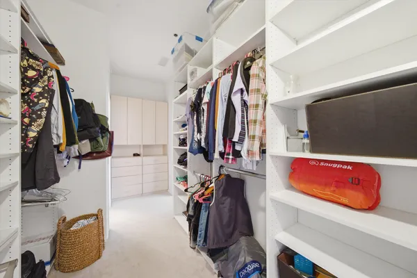 a view of walk in closet with clothes and shoes