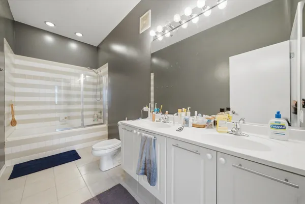 a bathroom with a double vanity sink toilet and a mirror