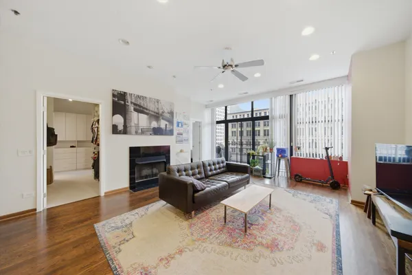 a living room with furniture large window and a fireplace