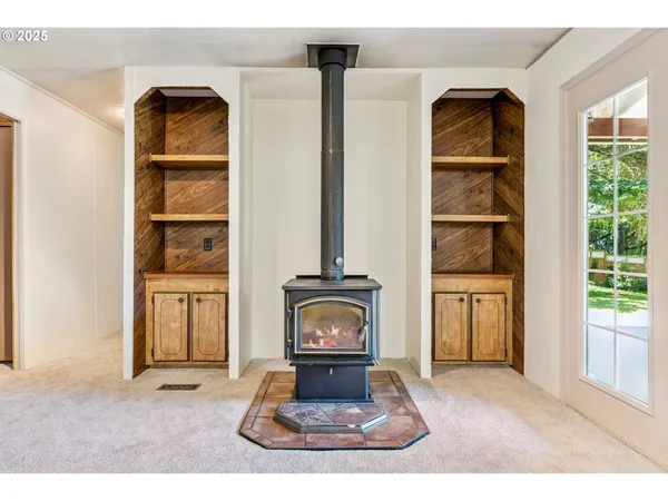 a view of an empty room with a fireplace and a large window