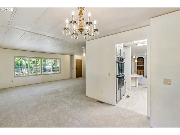 a view of an empty room with a fireplace and a window