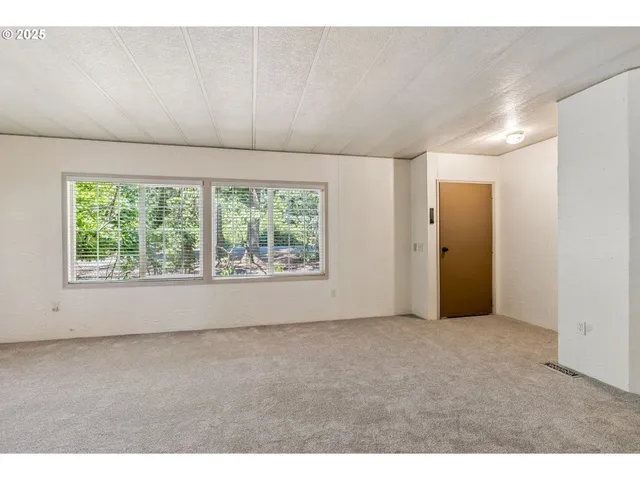 a view of an empty room with a fireplace and a window