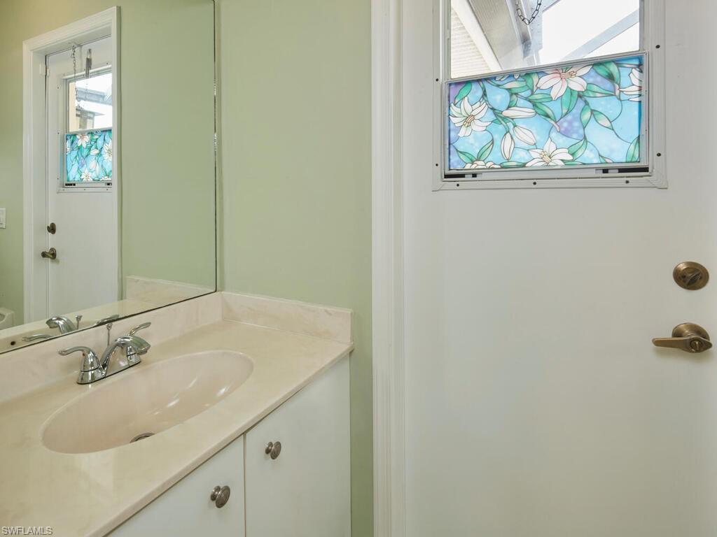 2126 East Crown Pointe Boulevard Naples, FL 34112 - Photo 14 of 26 a bathroom with a sink and a mirror
