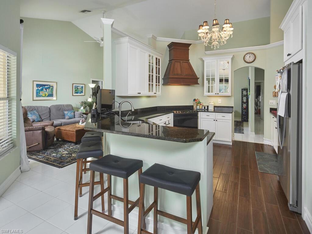 2126 East Crown Pointe Boulevard Naples, FL 34112 - Photo 6 of 26 a kitchen with a table chairs stove and refrigerator