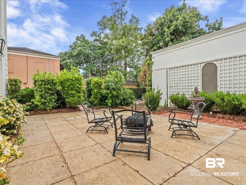 109 Eaton Square Mobile, AL 36608 - Photo 20 of 26 Expansive outdoor patio featuring large square pavers, surrounded by mature plantings and shrubs