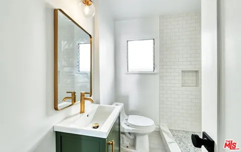 a bathroom with a sink a toilet and mirror