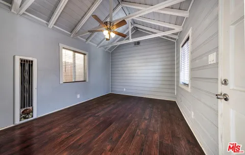 a room with white cabinets and wooden floor