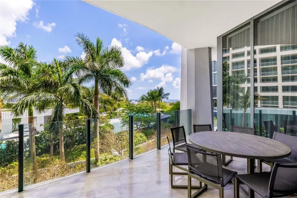 a living room with furniture a chandelier and a floor to ceiling window