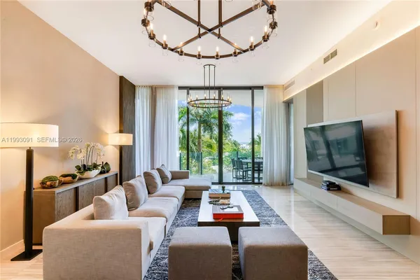 a living room with furniture a flat screen tv and a large window