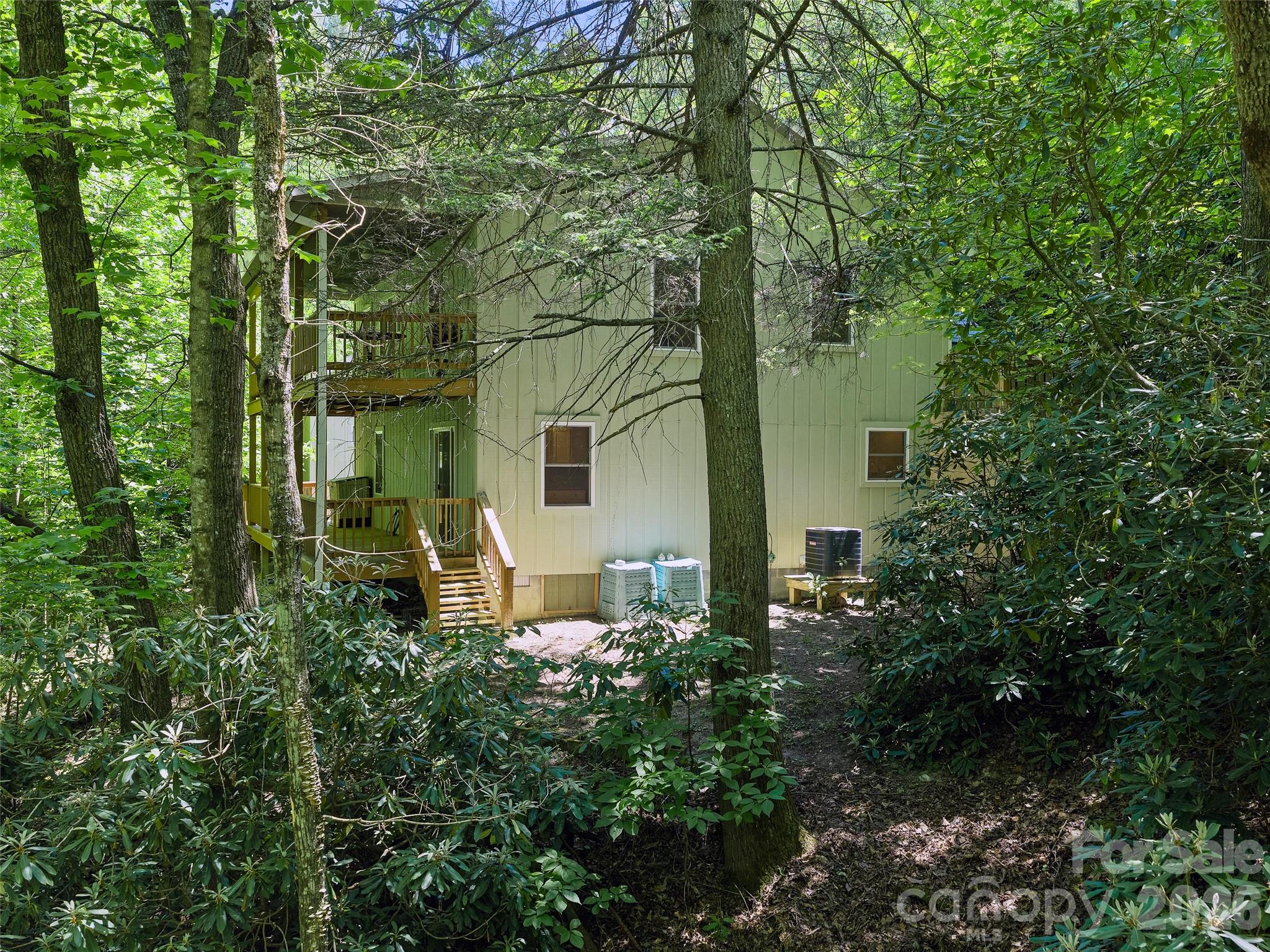 142 Wildflower Road Spruce Pine, NC 28777 - Photo 39 of 46 a backyard of a house with table and chairs and large trees