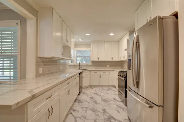 a kitchen with a refrigerator sink and cabinets