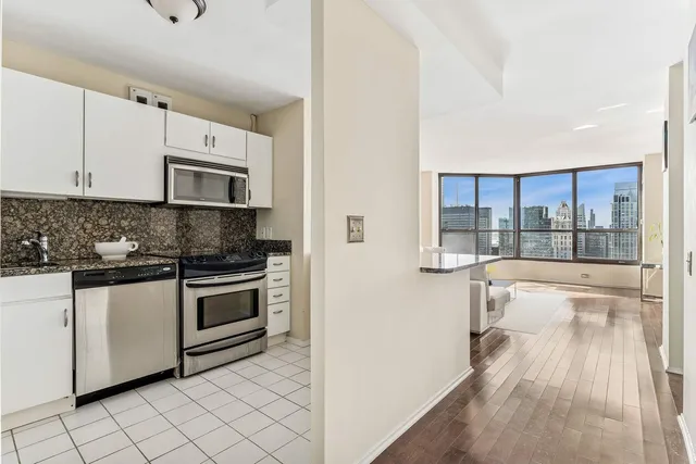 a kitchen with stainless steel appliances granite countertop a stove a sink and a microwave