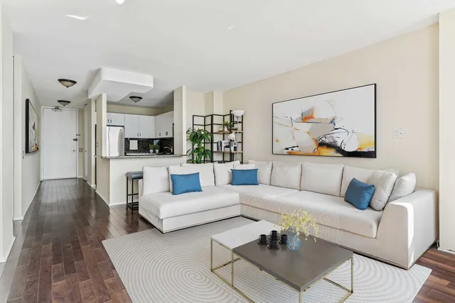 a living room with furniture and a view of kitchen