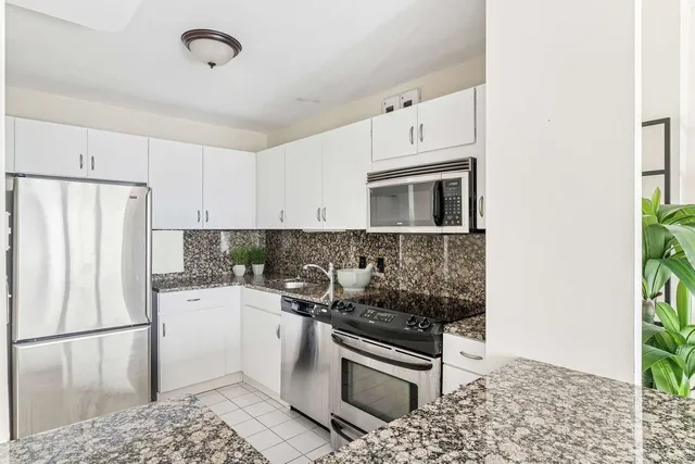 a kitchen with a refrigerator and a stove top oven