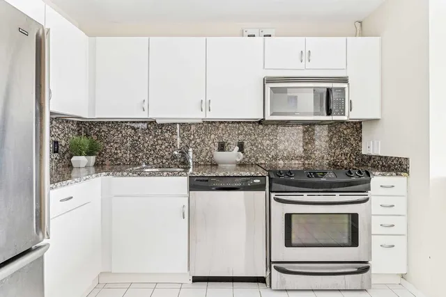 a kitchen with stainless steel appliances granite countertop a stove and a microwave
