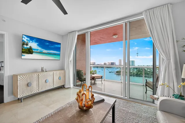 a living room with furniture a flat screen tv and a large window