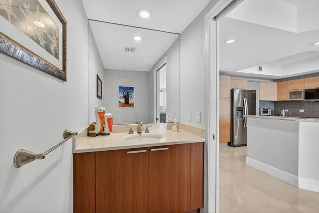 a bathroom with a sink a refrigerator and cabinets