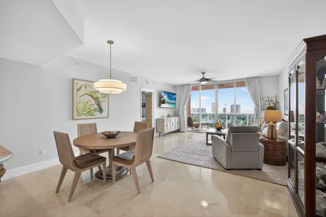 a dining room with wooden floor a chandelier a wooden table and chairs