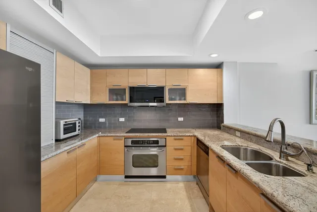 a kitchen with stainless steel appliances granite countertop a sink and a stove top oven