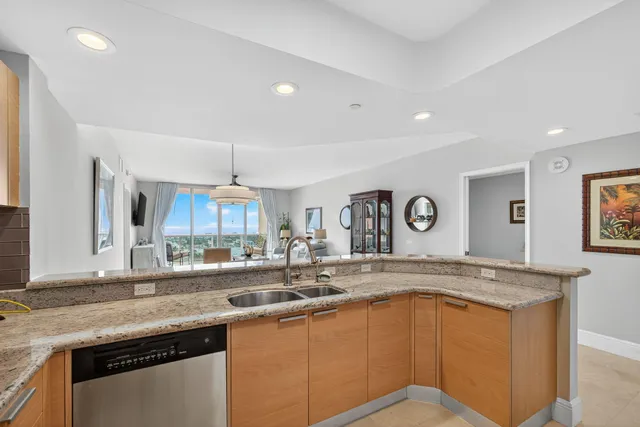 a kitchen with stainless steel appliances granite countertop a sink and dishwasher with wooden cabinets