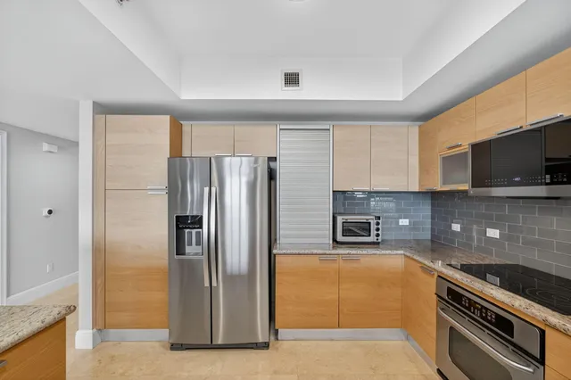 a kitchen with stainless steel appliances granite countertop a refrigerator and a stove