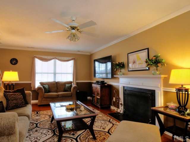 5645 Lighthall Lane Raleigh, NC 27604 - Photo 3 of 25 a living room with furniture a fireplace and a flat screen tv