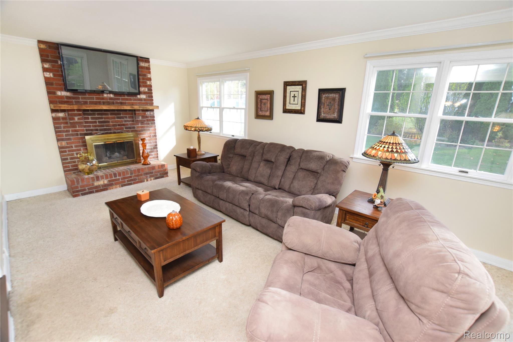 15489 Linden Road Linden, MI 48451 - Photo 4 of 25 Living room with crown molding, light colored carpet, and a fireplace