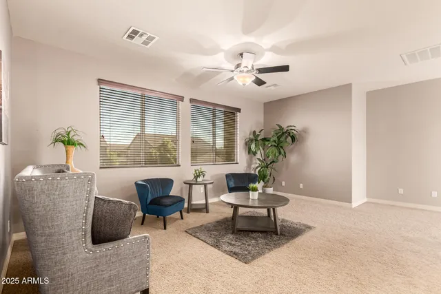 an empty room with windows and chandelier fan