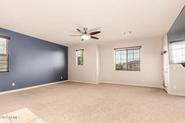 a view of a livingroom with a flat screen tv wooden floor and a ceiling fan