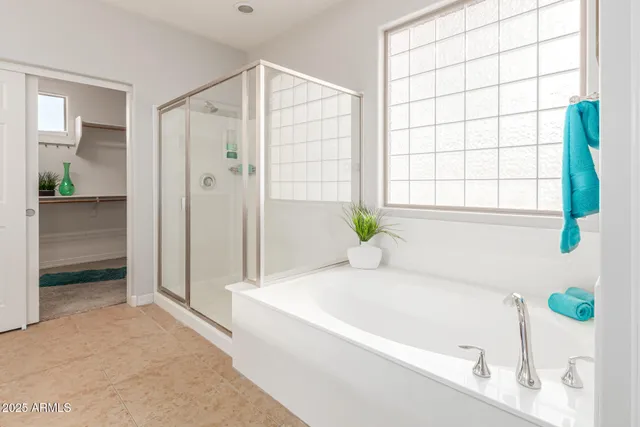 an empty room with chandelier fan and windows