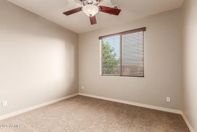 an empty room with windows and fan