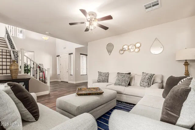 a living room with furniture and a wooden floor