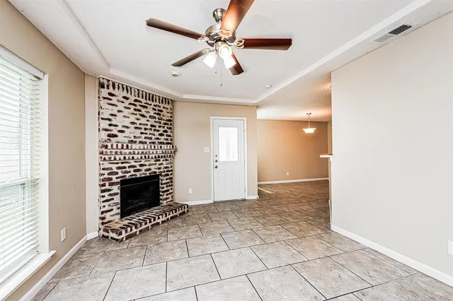 a view of an empty room with a fireplace and a window