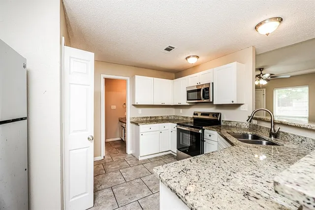 a kitchen with stainless steel appliances granite countertop a refrigerator stove microwave and sink