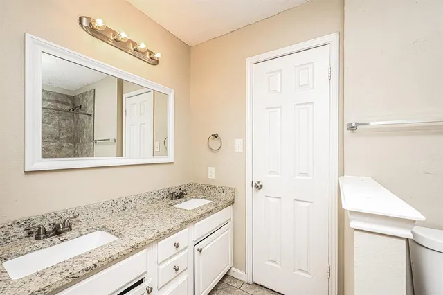 a bathroom with a granite countertop sink mirror and vanity