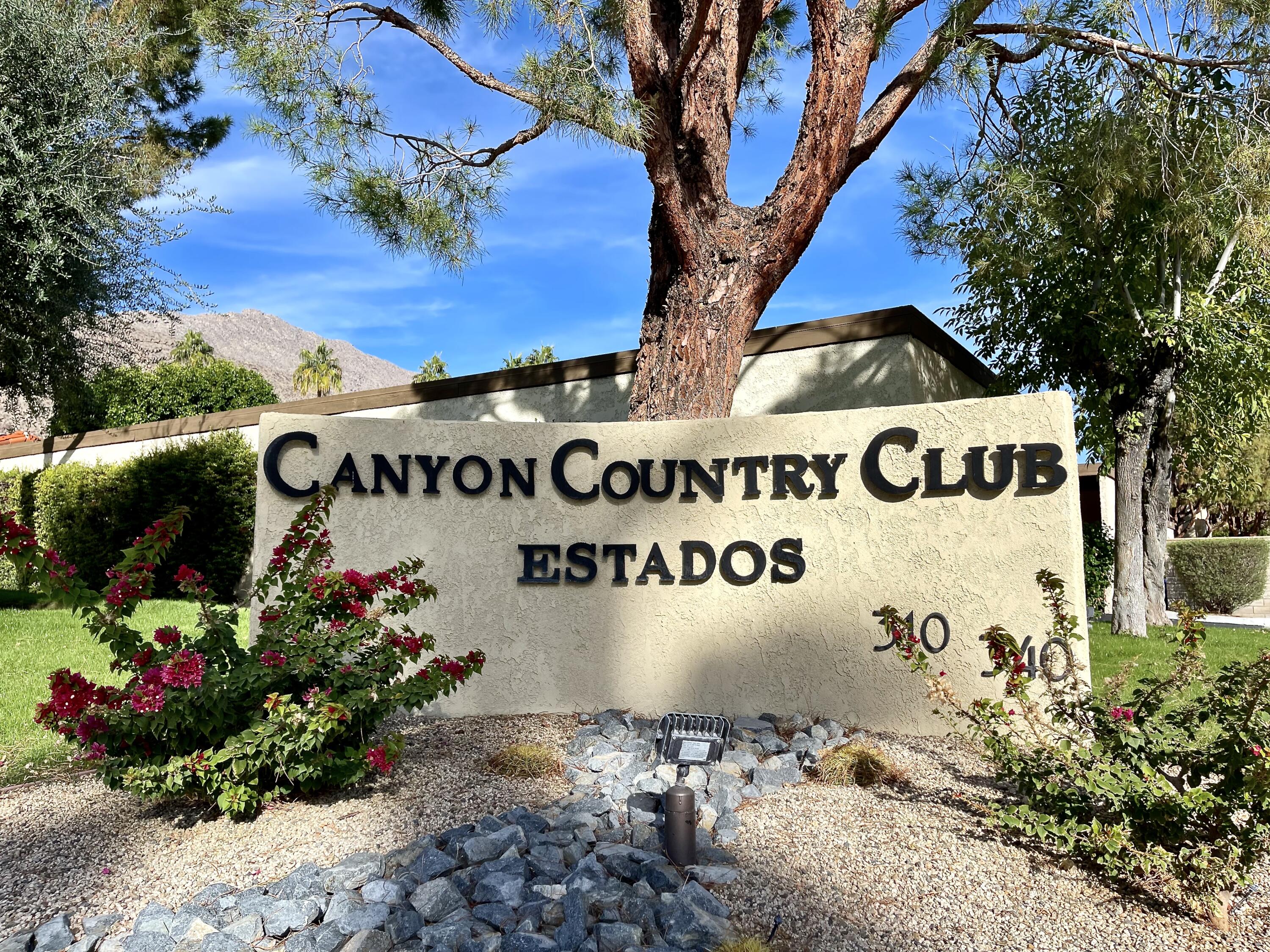 a sign that is sitting in front of flowers