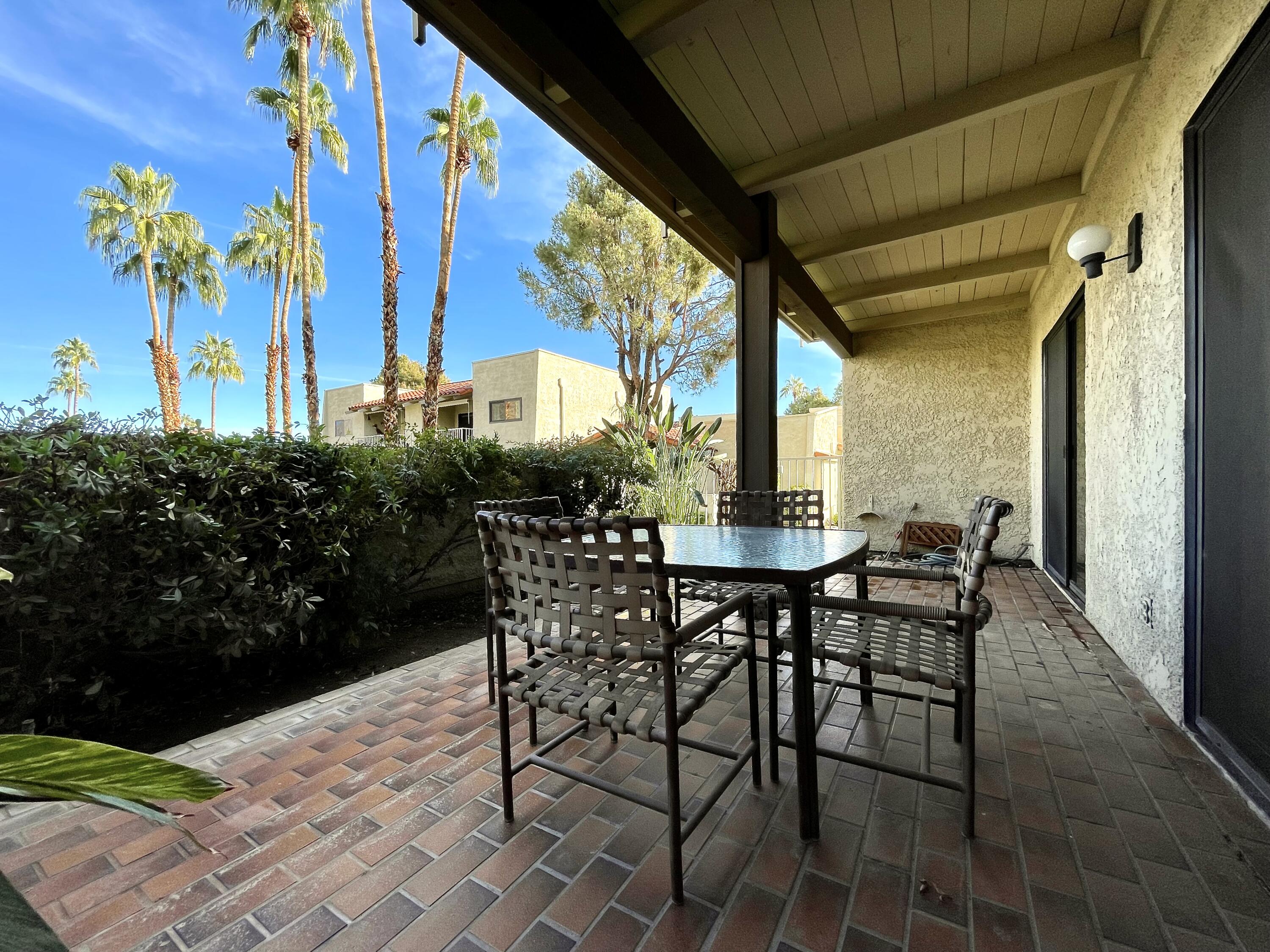 310 East San Jose Road, Unit 110 Palm Springs, CA 92264 - Photo 24 of 34 a view of an outdoor dining space with a table and chairs