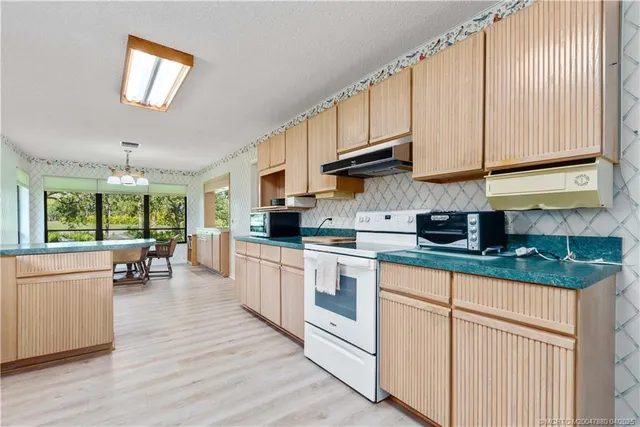 a kitchen with granite countertop white cabinets and white appliances