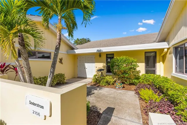 a front view of a house with plants