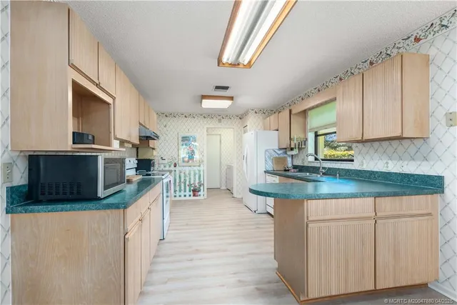 a kitchen with stainless steel appliances granite countertop a stove a sink and a microwave