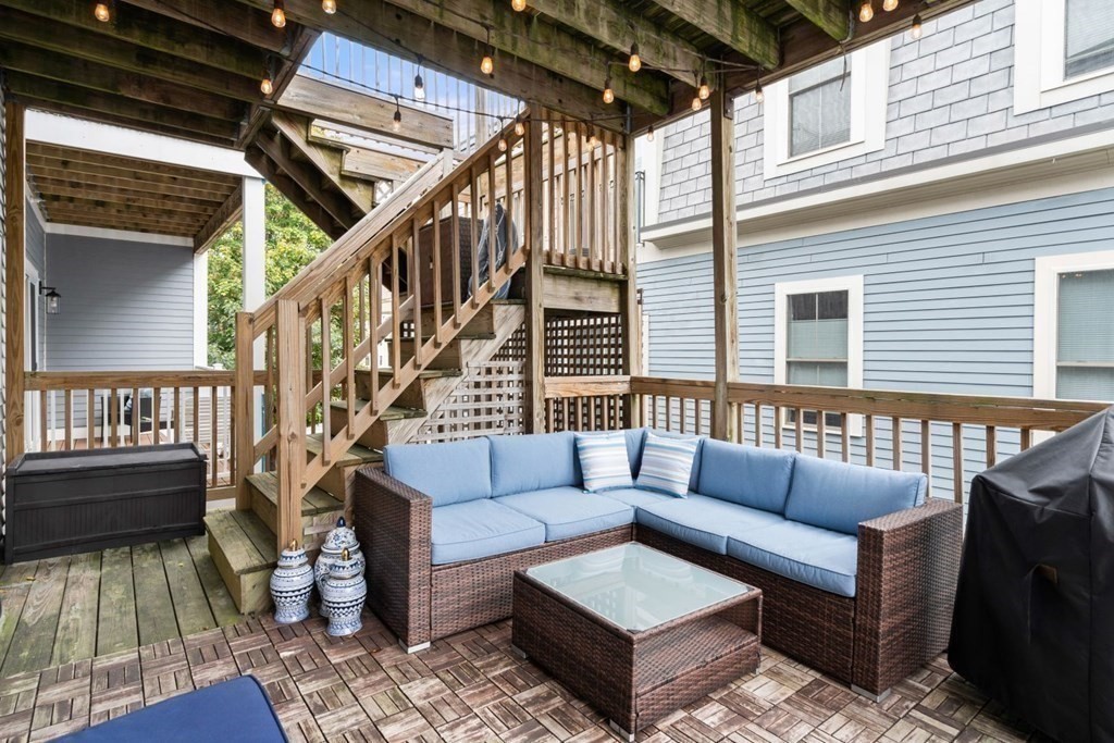 52 O Street, Unit 3 Boston, MA 02127 - Photo 14 of 15 a view of a patio with couches and a dining table and chairs with wooden floor