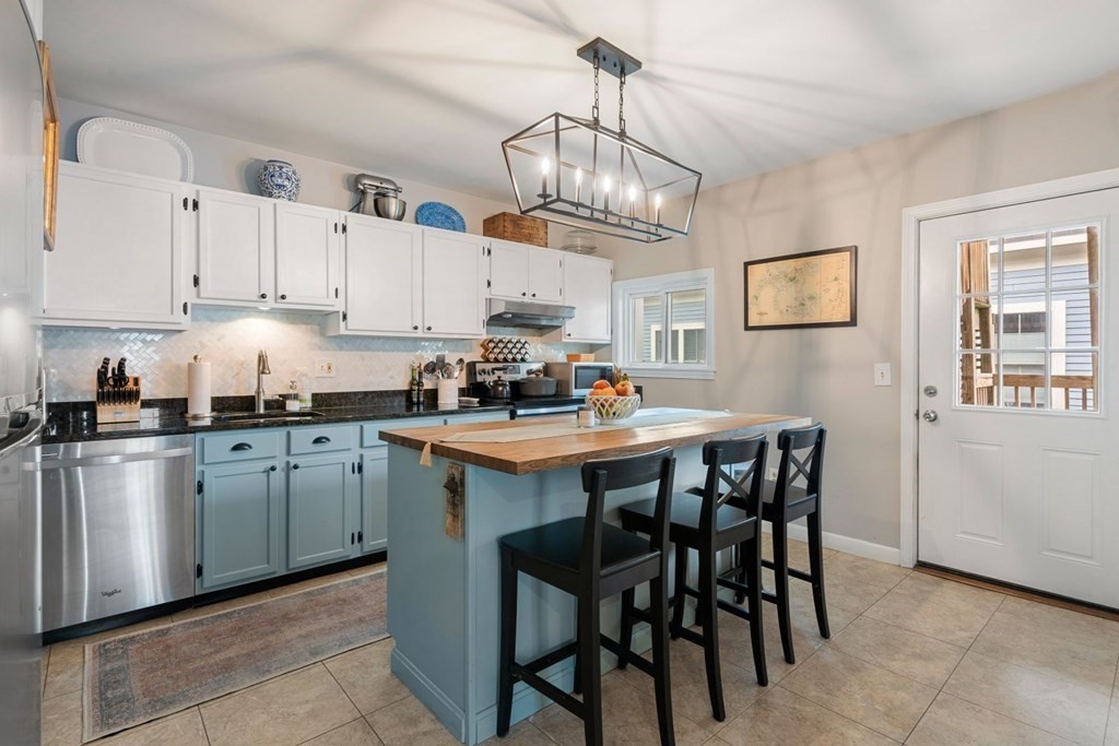 52 O Street, Unit 3 Boston, MA 02127 - Photo 3 of 15 a kitchen with stainless steel appliances granite countertop a sink a stove a dining table and chairs