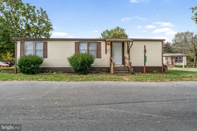 a front view of a house with a yard and potted plants