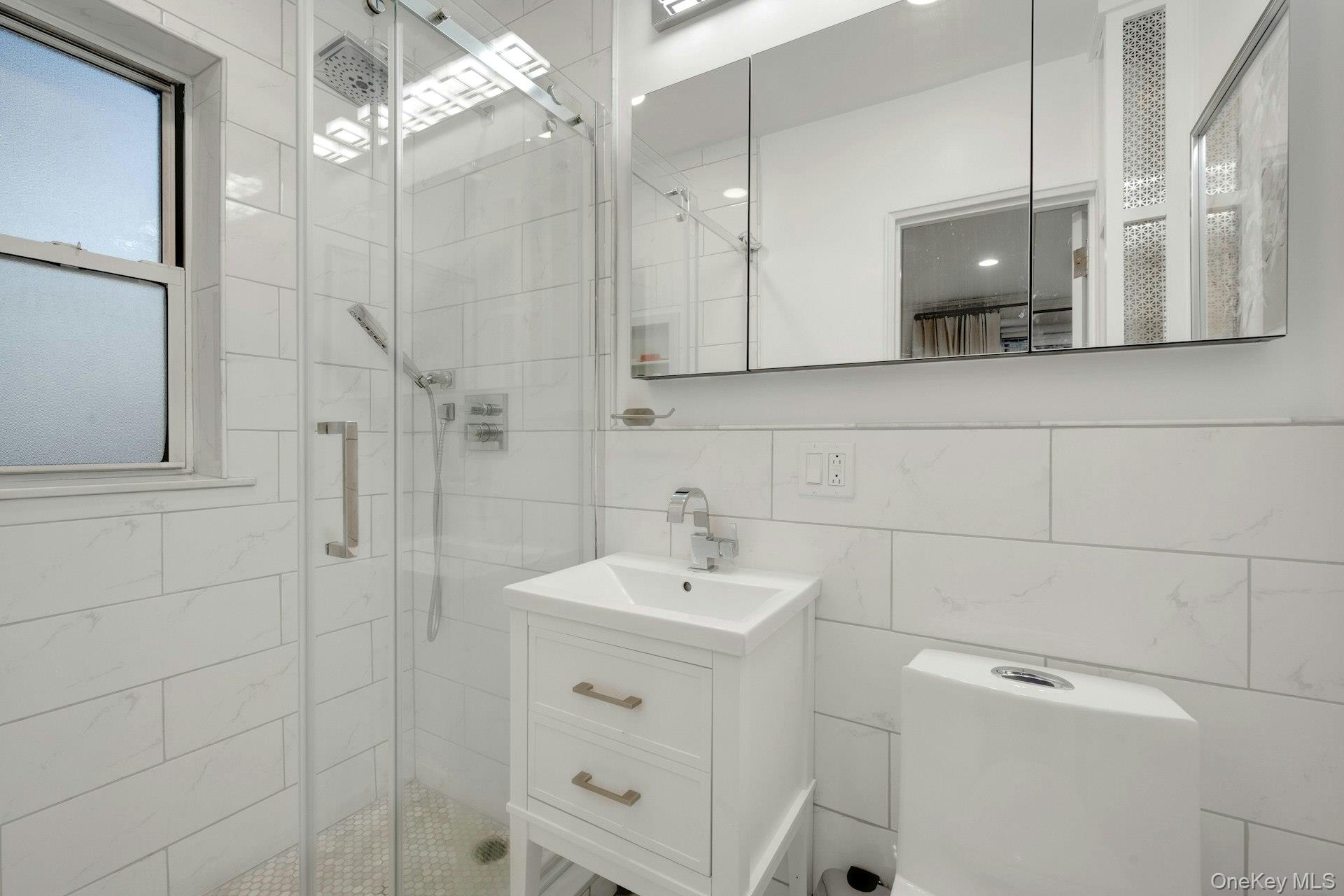 609 Palmer Road, Unit 2J Yonkers, NY 10701 - Photo 17 of 23 a bathroom with a sink a toilet and mirror