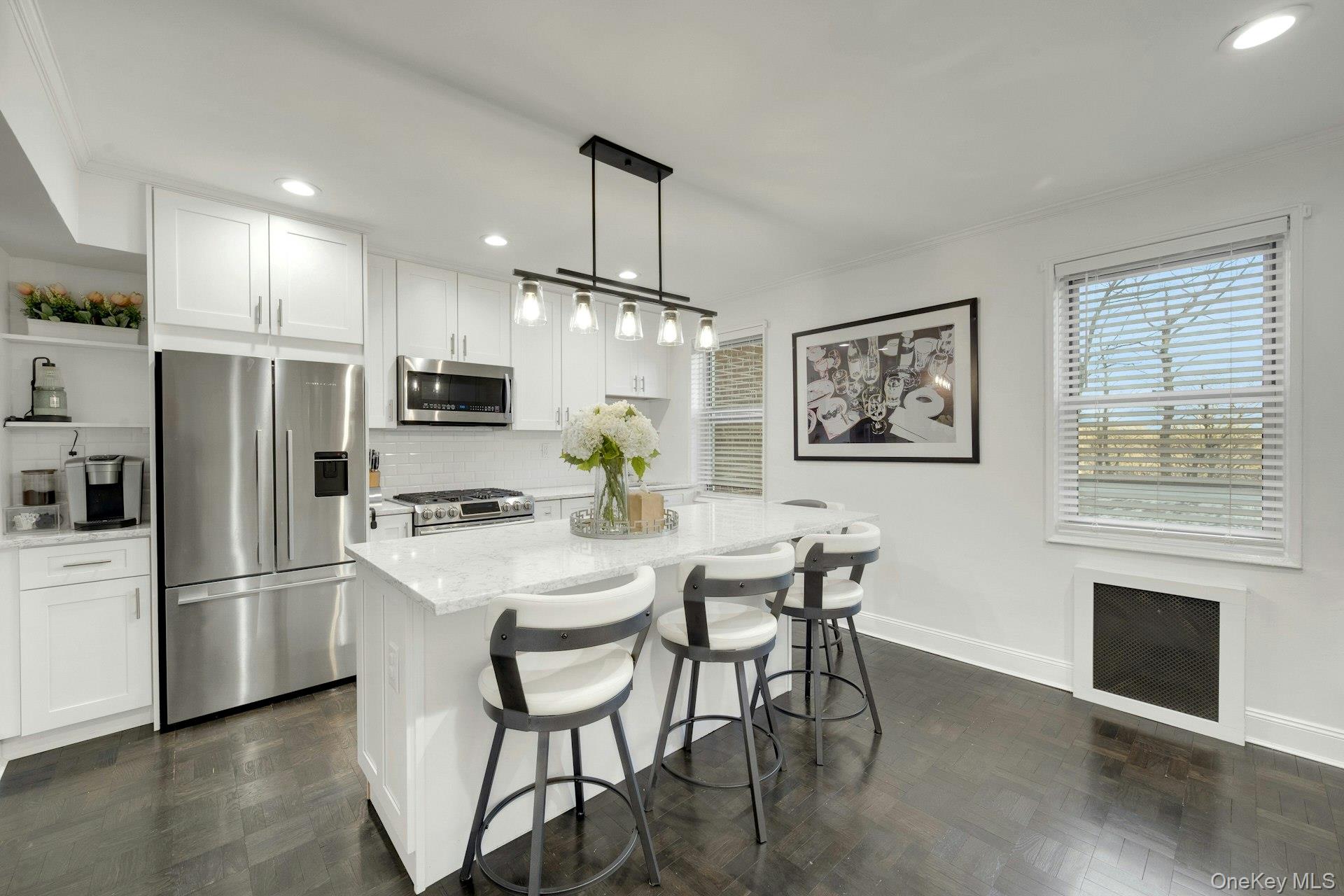 609 Palmer Road, Unit 2J Yonkers, NY 10701 - Photo 2 of 23 a kitchen with stainless steel appliances a refrigerator a stove a dining table and chairs